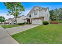 View of a charming two-story home with a well-manicured lawn and long driveway, ideal for Gathering living at 221 Hampton Station Blvd, Canton, GA 30115