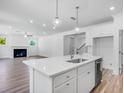 Open-concept kitchen boasts an island, stainless steel dishwasher, and connects to a spacious living area at 3311 Burkston Pl, Buford, GA 30519