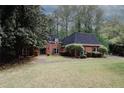 A lovely brick home featuring a well-kept lawn and mature trees in a tranquil setting at 110 Vistacrest Way, Roswell, GA 30075