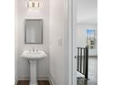 Stylish powder room with a pedestal sink, modern lighting, and neutral decor, conveniently located near the living area at 244 Church St, Lawrenceville, GA 30046
