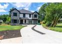 Modern two-story home with gray and white facade, featuring a concrete driveway with landscaped center and lush greenery at 2740 Drew Valley Ne Rd, Brookhaven, GA 30319