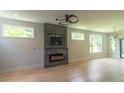Bright living room showcasing hardwood floors, a fireplace with stone surround and a contemporary ceiling fan at 2740 Drew Valley Ne Rd, Brookhaven, GA 30319