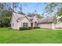 Well-manicured lawn surrounds this lovely home with neutral siding at 155 Oak Terrace Dr, Covington, GA 30016