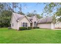 Inviting home featuring a spacious front yard, charming curb appeal, and a side-entry two-car garage at 155 Oak Terrace Dr, Covington, GA 30016