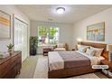 Cozy staged bedroom featuring a queen bed, dresser, and large window offering natural light at 2012 Elm Grove Ln, Hampton, GA 30228