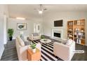 Bright, staged living room featuring a fireplace, ceiling fan, stylish furnishings, and hardwood floors at 2012 Elm Grove Ln, Hampton, GA 30228