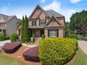 Attractive brick home with verdant landscaping, symmetrical shrubbery, and a stone-paved walkway at 4190 Madison Dr, Cumming, GA 30040