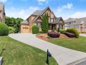 Beautiful two-story home with a well-maintained lawn, curved driveway, and lush landscaping at 4190 Madison Dr, Cumming, GA 30040