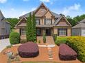 Inviting brick home featuring manicured shrubbery, lush green lawn, and charming front entrance at 4190 Madison Dr, Cumming, GA 30040