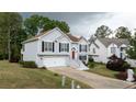 Charming home with an attached garage, landscaped front yard, and a bright orange front door on a sunny day at 440 Hickory Glen Sw Ln, Atlanta, GA 30311