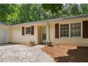 Cozy home featuring brown shutters, a light-colored exterior, and well-maintained landscaping around the front entrance at 6292 Field Glen Rd, Stone Mountain, GA 30087
