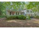 Charming two-story home featuring an inviting front porch, wood siding, and a double garage in a serene wooded setting at 2675 Paul Thomas Dr, Dacula, GA 30019