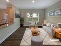 Bright, staged living room features a gray couch, a decorative area rug, and hardwood floors at 7721 Fawn Cir, Covington, GA 30014