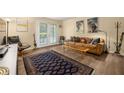 Bright living room with neutral walls, a brown leather couch, and a patterned rug over the hardwood floors at 3472 Essex Ave # 81, Atlanta, GA 30339