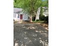 A single Gathering house shows a spacious paved driveway and a large tree in the front yard for curb appeal at 1047 Plantation Way, Kennesaw, GA 30301