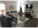 Cozy living room with fireplace, large TV, wood floors, and ample seating with neutral tones at 1047 Plantation Way, Kennesaw, GA 30301