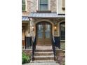 Inviting double front door with brick steps, black railings, and stylish outdoor lighting at 396 15Th Nw St # 6, Atlanta, GA 30318