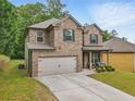 Lovely two-story home with brick and siding, a manicured lawn, and a welcoming front porch at 11028 Southwood Dr, Hampton, GA 30228
