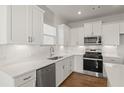 Well-lit kitchen showcasing white cabinetry, stainless steel appliances, and sleek countertops at 488 Village Ln, Fairburn, GA 30213