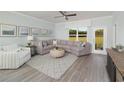 Inviting living room featuring a large sectional sofa, stylish decor, and expansive windows overlooking the backyard at 488 Village Ln, Fairburn, GA 30213