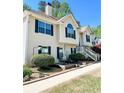 Charming two-story home with a well-manicured lawn, lush landscaping, and welcoming entrance stairs at 3809 Autumn View Nw Ln, Acworth, GA 30101