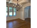 Elegant dining area with hardwood floors, coffered ceilings, and a modern chandelier, creating an inviting ambiance at 4015 Sierra Vista Cir, Cumming, GA 30040