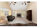 Inviting living room boasts a stone fireplace, ceiling fans and a vaulted ceiling at 4572 Mulberry Fields Ln, Auburn, GA 30011