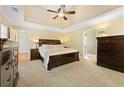 Bright main bedroom featuring a tray ceiling, neutral carpet and large dressers at 4572 Mulberry Fields Ln, Auburn, GA 30011