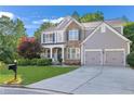 Charming two-story home with stone accents, a well-manicured lawn, and a two-car garage at 4325 Acanthite Ct, Cumming, GA 30040