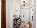Bright entryway featuring a hardwood floor, console table and view of the white front door with a glass accent at 109 Aspen Way, Dallas, GA 30157