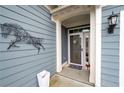Covered front porch with decorative wall art, potted plants, and a security screen door at 109 Aspen Way, Dallas, GA 30157