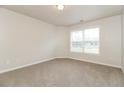 Bright bedroom featuring neutral walls, plush carpeting, a large window with blinds, and ample natural light creating a cozy space at 194 Wilhelmina Dr, Austell, GA 30168