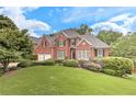 Beautiful brick home with lush landscaping, black shutters, and a two-car garage at 3348 Perrington Pointe, Marietta, GA 30066
