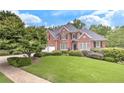 Beautiful two-story brick home featuring a lush green lawn and mature trees at 3348 Perrington Pointe, Marietta, GA 30066