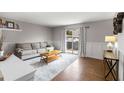 Well-lit living room features wood trim, hardwood floors, stylish furniture, and a sliding door to the outside at 3501 Roswell Ne Rd # 102, Atlanta, GA 30305