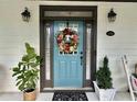 A welcoming front door adorned with a wreath and flanked by plants, creating a charming entrance at 178 Mission Oak Dr, Grayson, GA 30017