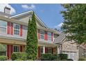 Close-up of a home's exterior with stone accents and red shutters, highlighting its curb appeal at 3133 Bridge Walk Dr, Lawrenceville, GA 30044