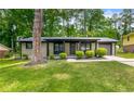 Charming single-story home with a well-manicured lawn and a covered front porch and attached garage at 4158 Pepperdine Dr, Decatur, GA 30034