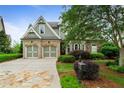 Charming home exterior featuring brick and siding, an attached garage, a lush lawn, and well-maintained landscaping at 2490 Hillandale Cir, Cumming, GA 30041