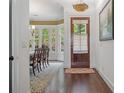 Elegant foyer showcasing hardwood floors, a wooden front door, and an arched doorway leading to the dining room at 2490 Hillandale Cir, Cumming, GA 30041