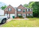 Traditional brick home with a lush green lawn, two-car garage, and driveway basketball hoop at 4041 Smithfield Trl, Ellenwood, GA 30294