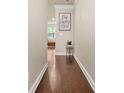 Hallway featuring hardwood floors, a picture frame, and trim throughout at 241 Irwell Path, Lawrenceville, GA 30044