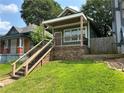 Charming renovated home with a covered porch, stone accents, new wooden steps, and fresh landscaping at 490 Rockwell Sw St, Atlanta, GA 30310