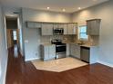 Open concept kitchen with stainless steel appliances, granite countertops, and wood floors at 490 Rockwell Sw St, Atlanta, GA 30310