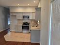 Well-lit kitchen with stainless steel appliances, light gray cabinets and a tiled backsplash at 490 Rockwell Sw St, Atlanta, GA 30310