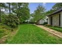 Expansive lawn surrounded by lush greenery, leading to a beautiful home at 5120 Jett Forest Trl, Atlanta, GA 30327