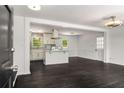 Open-concept living space with hardwood floors, seamlessly connecting to a modern kitchen island at 157 Jousters Ln, Lawrenceville, GA 30044