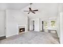 Spacious living room featuring a fireplace, ceiling fan, and entry to the kitchen at 332 Christian Ln, Carrollton, GA 30116