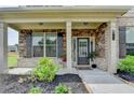 Inviting front porch showcases a stone facade, manicured landscaping, and a stylish entrance at 3985 Foxdale Ln, Cumming, GA 30028