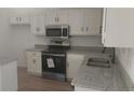 Kitchen features modern appliances, granite countertops, white cabinets, and stainless steel faucet at 991 Park Creek Cir, Lawrenceville, GA 30044